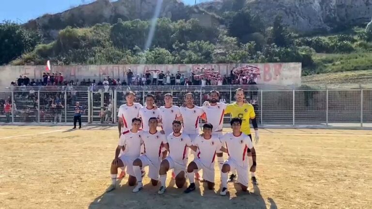La squadra del Bovo Marina Montallegro in posa in campo, con i tifosi biancorossi sugli spalti