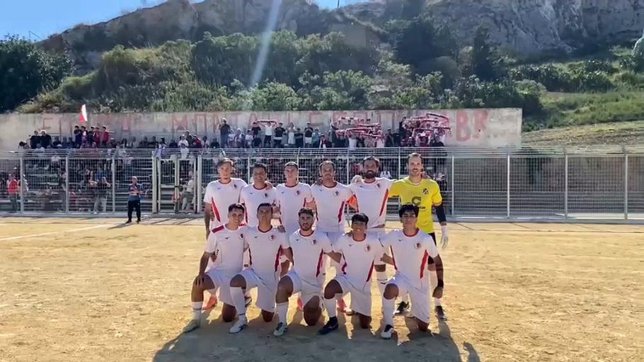 La squadra del Bovo Marina Montallegro in posa in campo, con i tifosi biancorossi sugli spalti